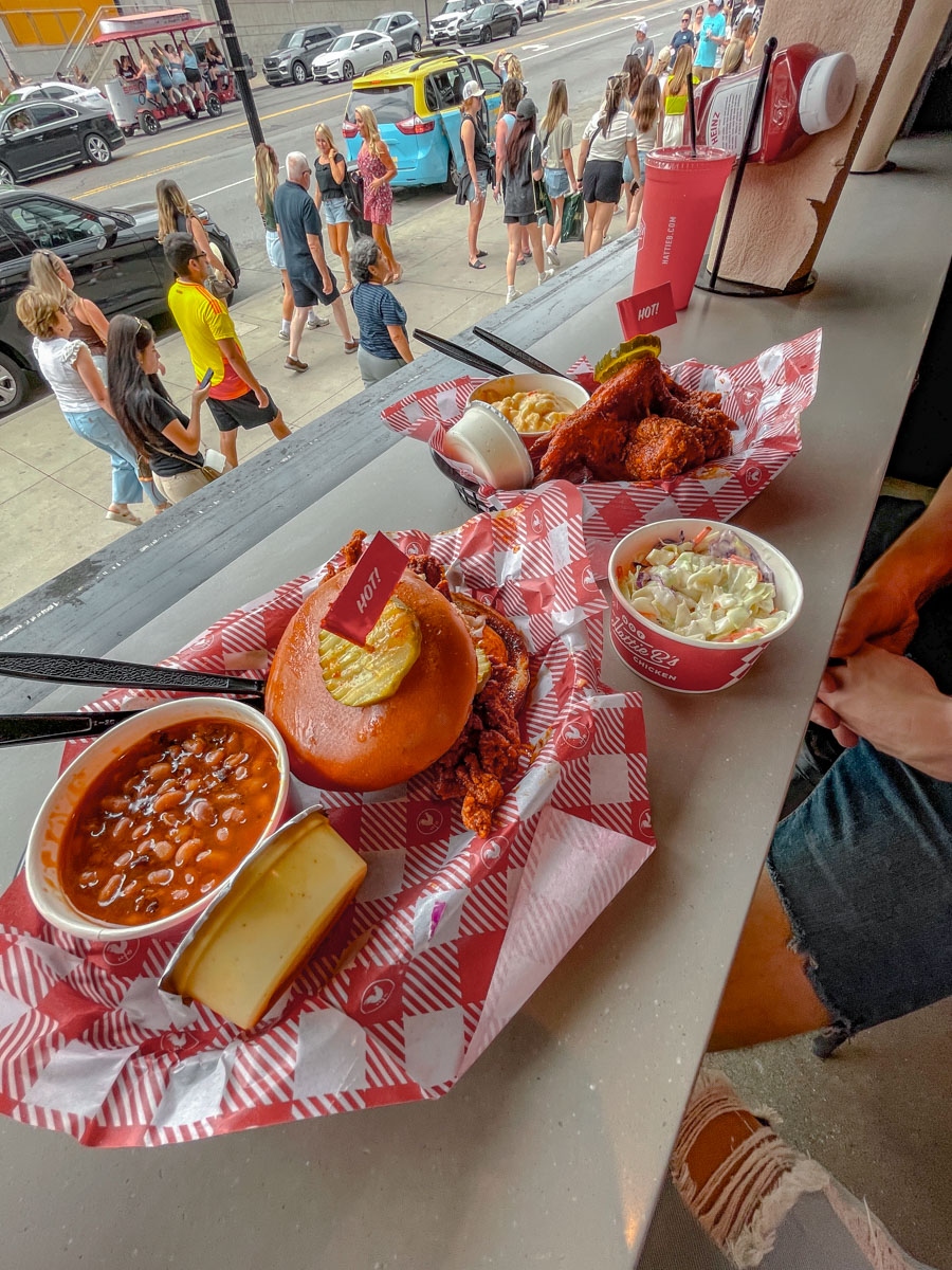 Servings of burgers, hot chicken, beans stew, and vegetables at a restaurant in Nashville.
