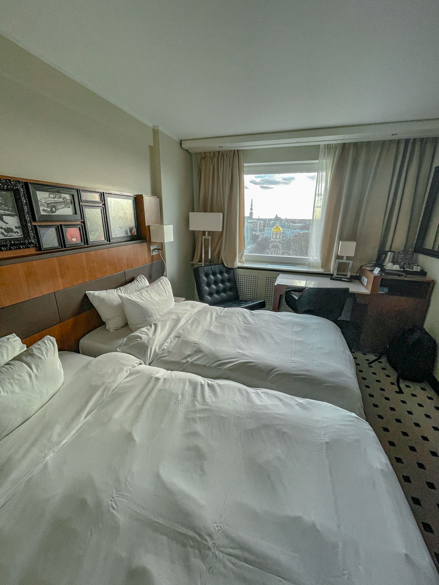 Hotel room with two double beds and a view of Riga city.