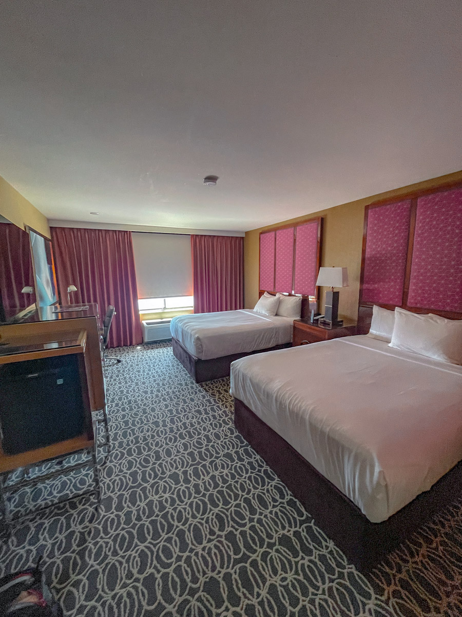 Two beds inside a carpeted hotel room.