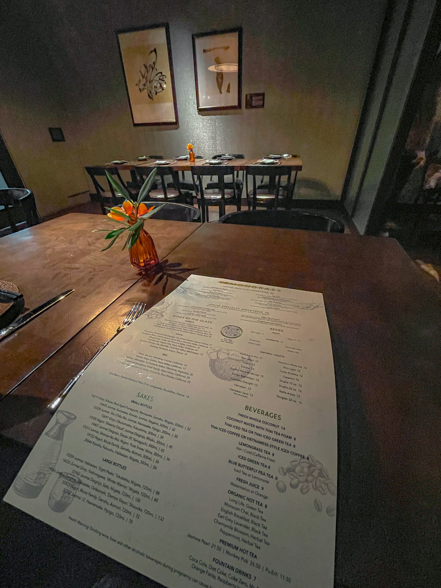 A restaurant menu sitting on a wooden table in a hotel restaurant.