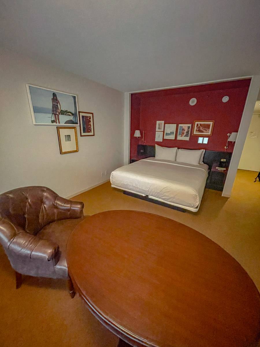 Inside a carpeted hotel room with a bed, chair, and round table in Park MGM Las Vegas.