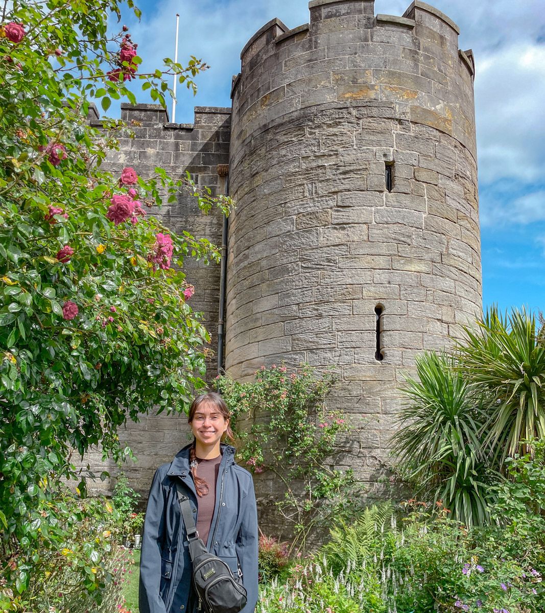 A woman standing in front of Stirling Castle and gardens in Scotland.
