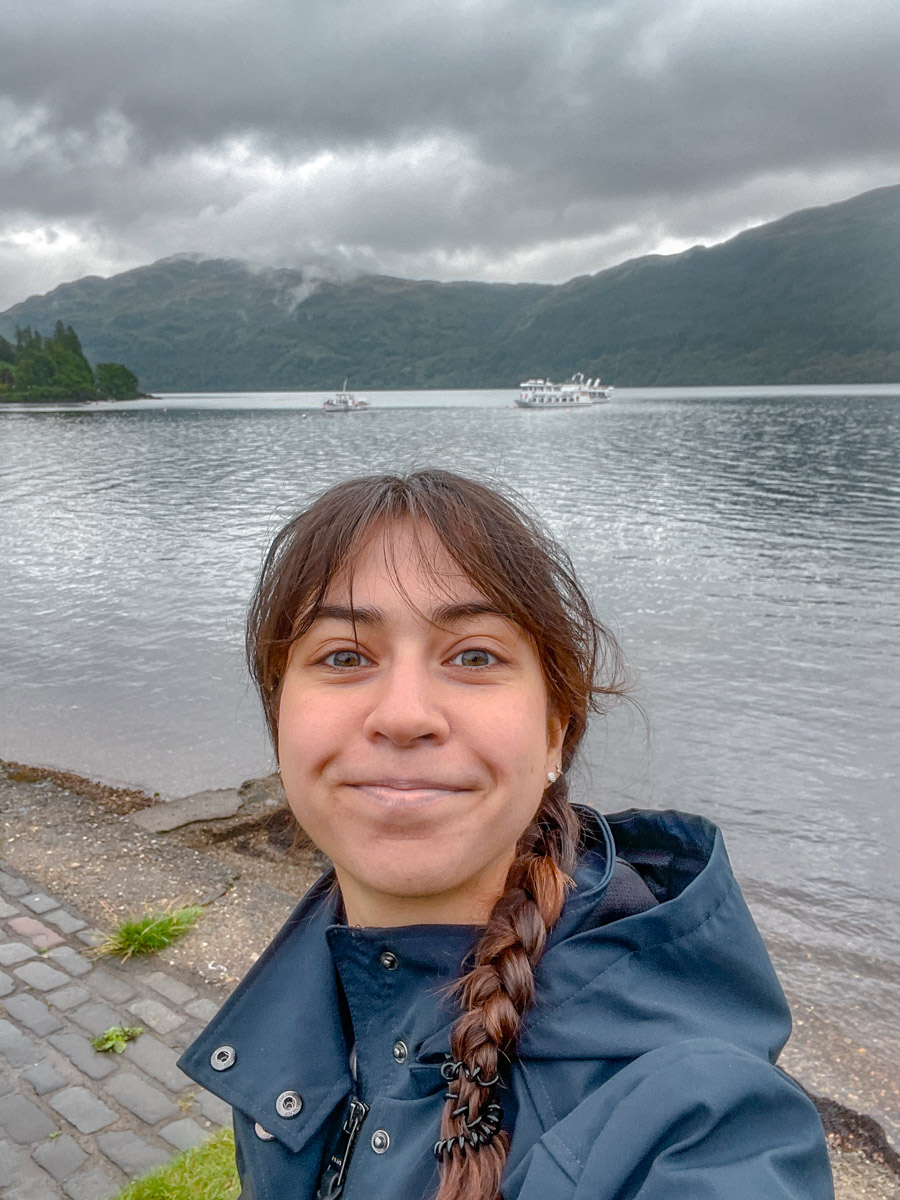 A woman standing in front of a lake in Scotland.