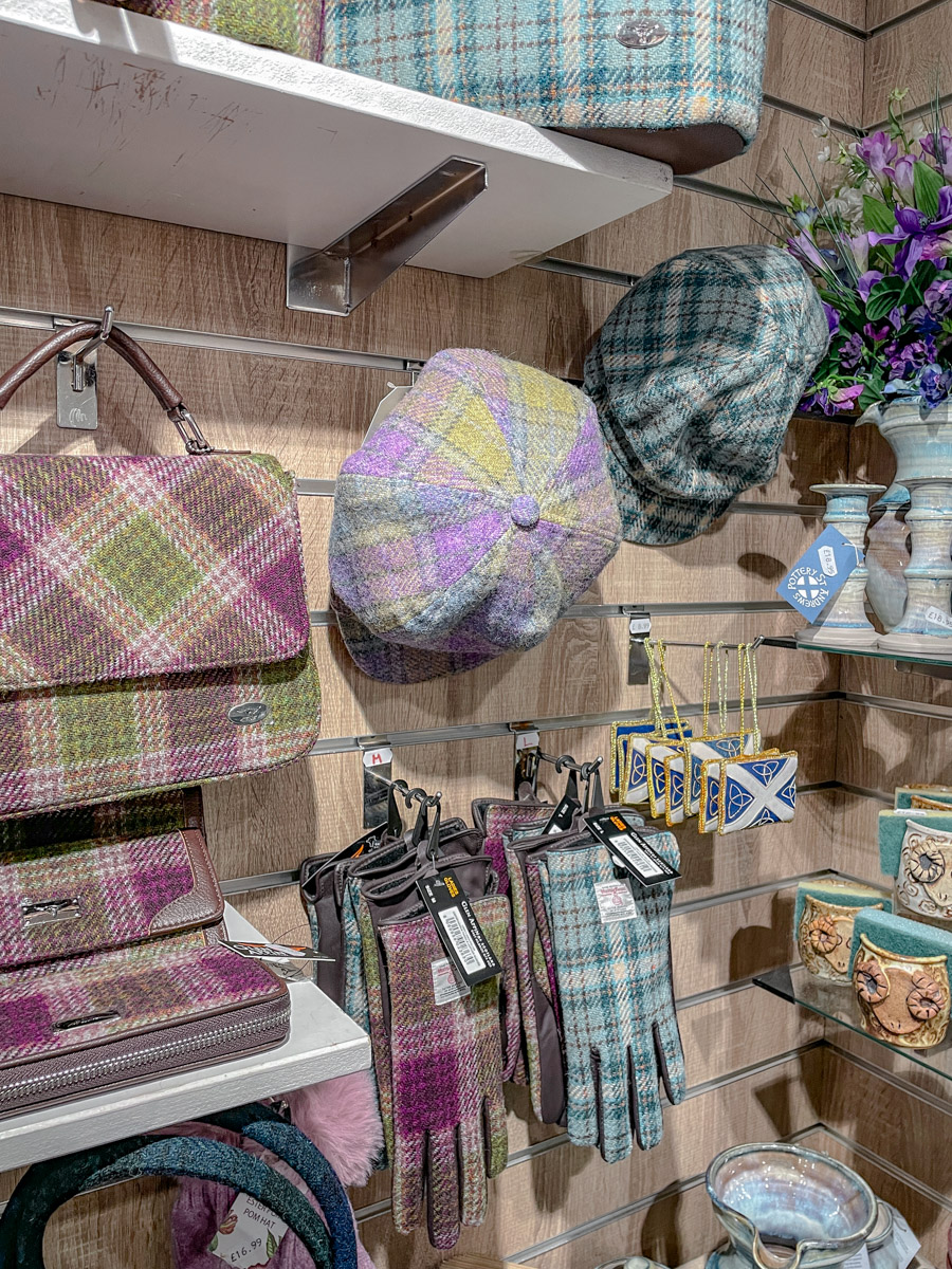 Various items like gloves, bags, and caps made out of Scottish wool scarves.
