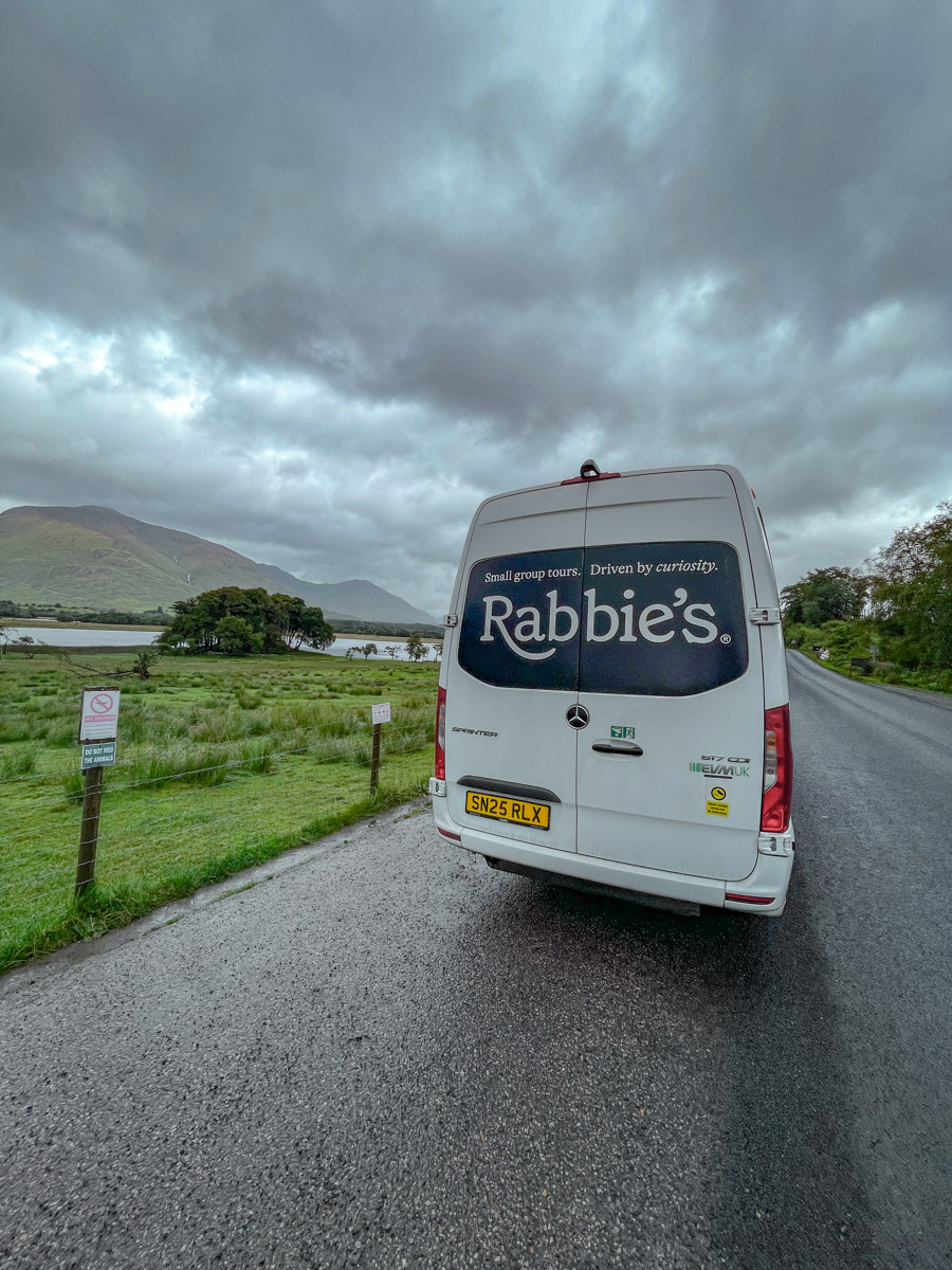 The back of a van on a road in the Scottish highlands.