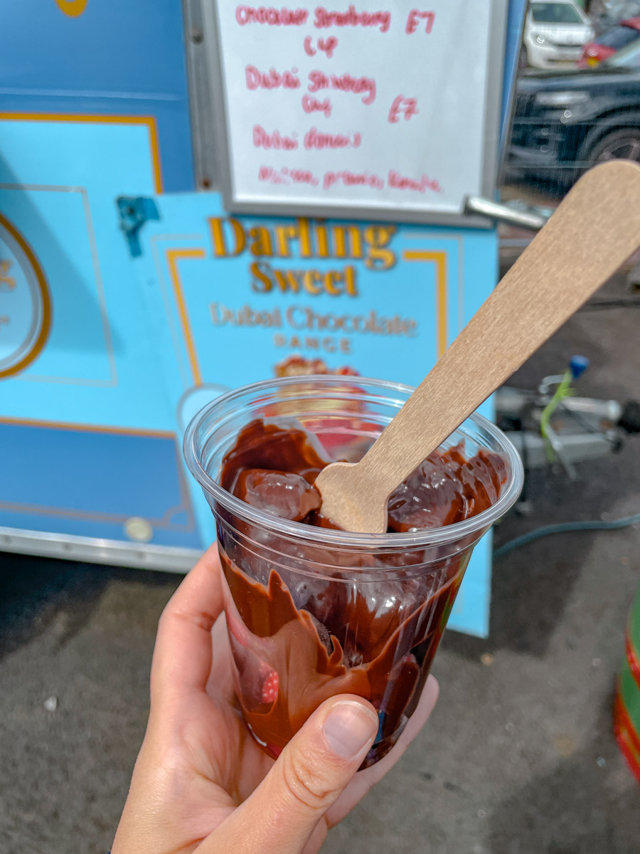 Chocolate-covered strawberries in a plastic cup.