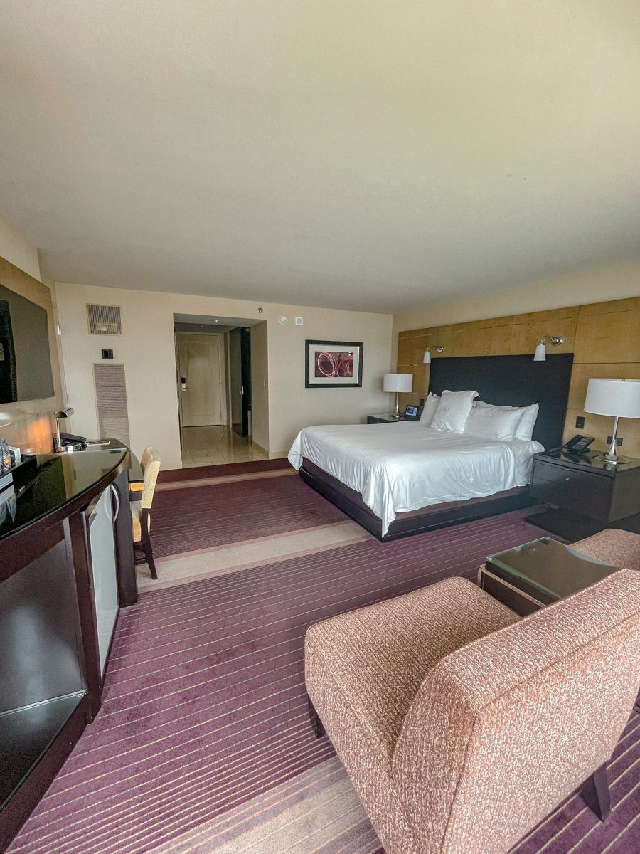 Hotel room with bed, chairs, counter in Aria Las Vegas.